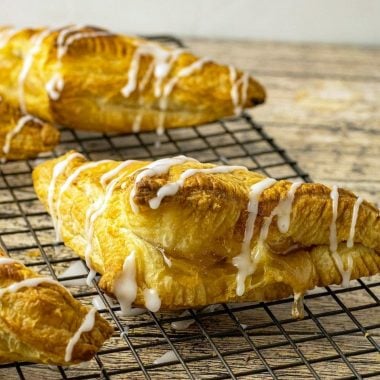 Easy Apple Turnovers made with puff pastry & apple pie filling for a simple, delicious apple dessert. Puff Pastry Apple Turnover Recipe is made in minutes & topped with a delicious almond glaze.