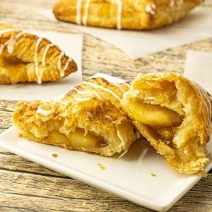 apple turnovers sliced in half on a white plate