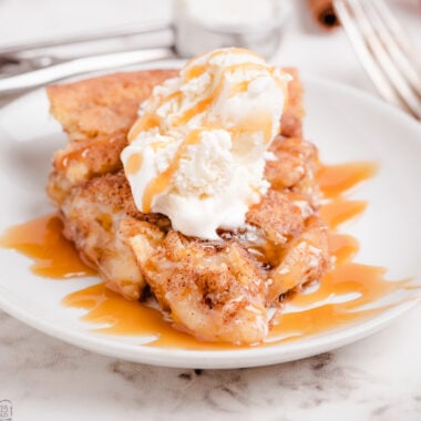 slice of Snickerdoodle Apple pie on a white plate drizzled with caramel