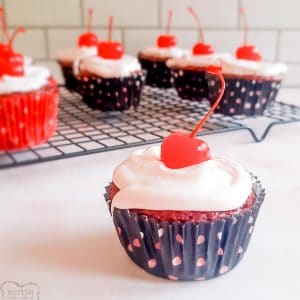 cherry cola cupcakes with white frosting and a cherry on top