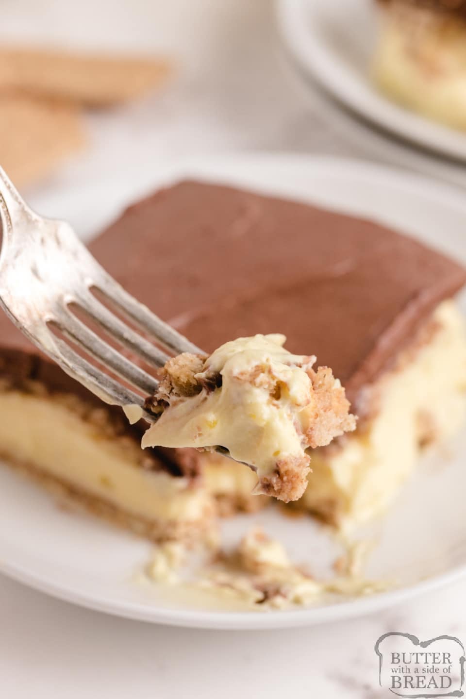 No Bake Eclair Cake made with graham crackers, vanilla pudding and a delicious fudgy chocolate frosting layer on top. This no bake chocolate eclair dessert tastes just like a cream puff!
