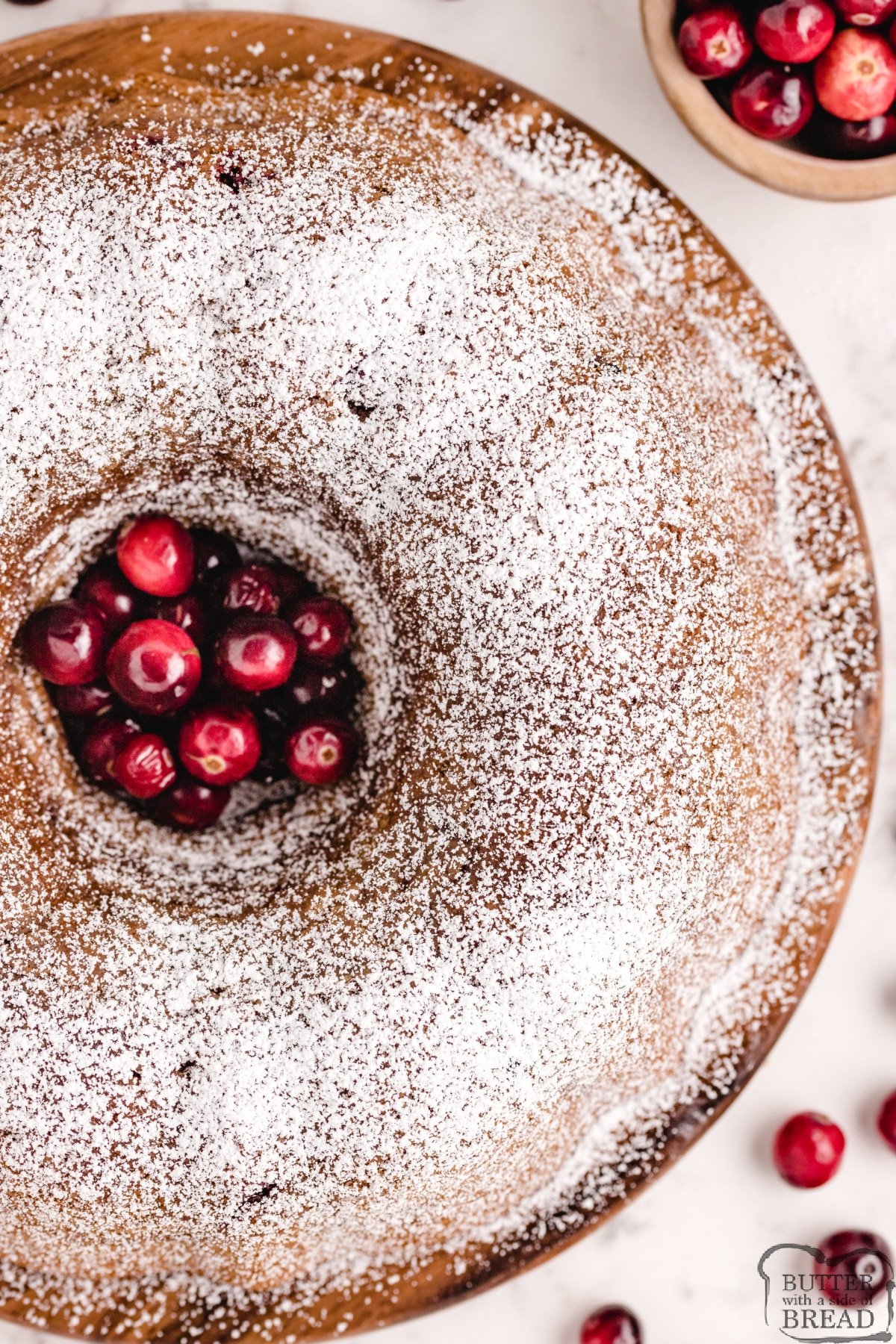 Cranberry Pumpkin Bundt Cake recipe that is made with pumpkin and fresh cranberries. Made in a bundt pan and sprinkled with powdered sugar, this delicious from scratch pumpkin cake recipe is perfect for fall! 