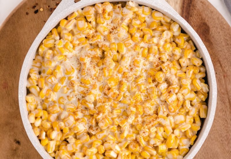 easy homemade creamed corn recipe in a saucepan on a wooden tray