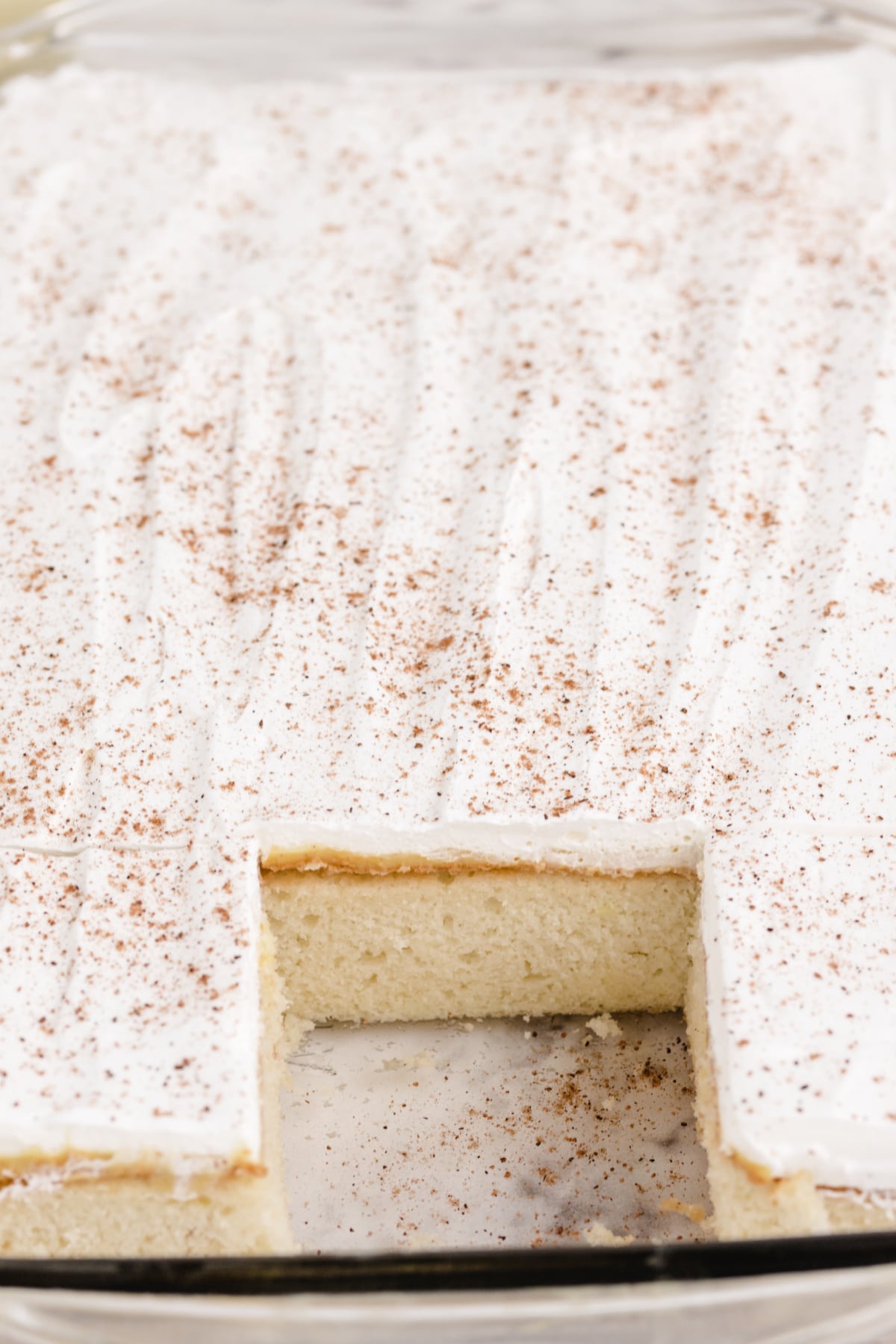 Eggnog Poke Cake made with a white cake mix, eggnog, vanilla pudding, and cool whip. Delicious moist cake recipe perfect for the holidays!