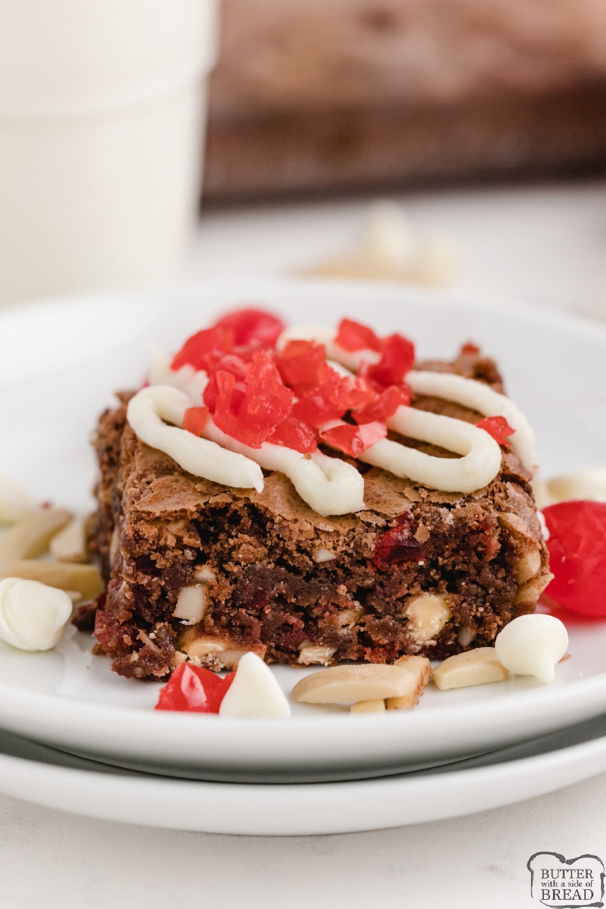 Black Forest Brownies made with a delicious, from-scratch brownie recipe that is mixed with white chocolate chips, chopped cherries and slivered almonds. The brownies are then topped with a cream cheese frosting and more cherries!