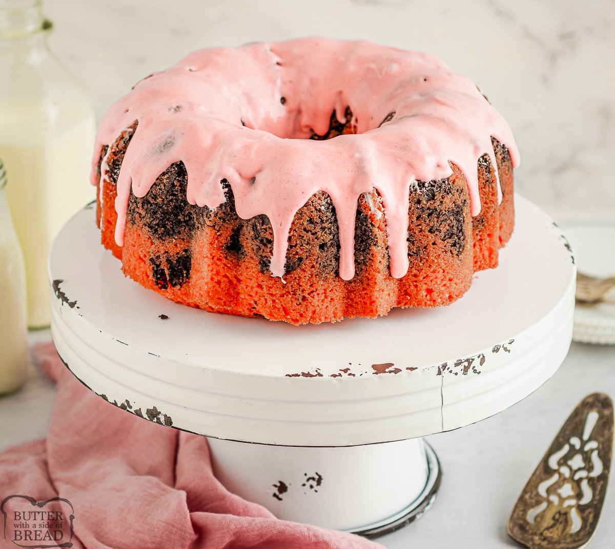 strawberry bundt cake on a white cake pedestal