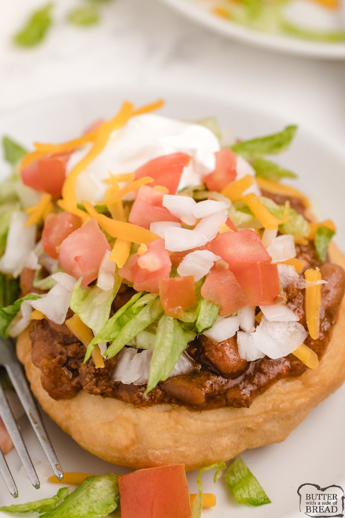 Simple fry bread topped with chili, cheese, lettuce, tomatoes, onions and sour cream