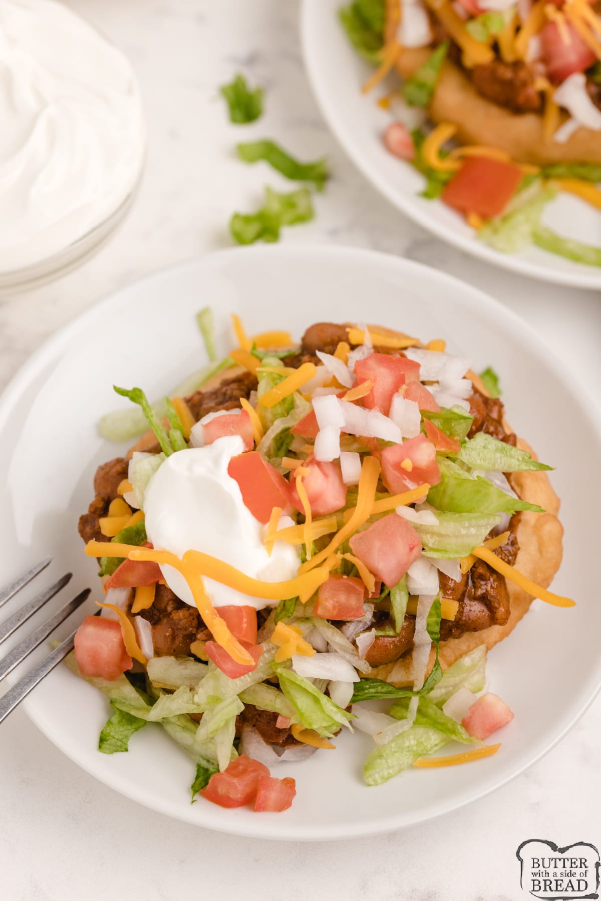 Navajo Tacos are perfect for an easy dinner. Simple homemade fry bread topped with chili, lettuce, tomatoes, cheese, onions and sour cream. 