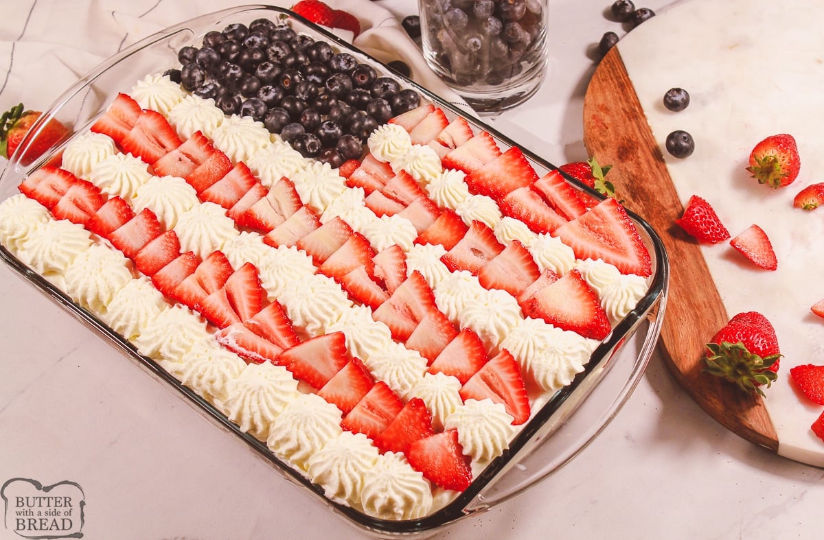 berries and whipped cream on top of a tres leches cake for Memorial Day