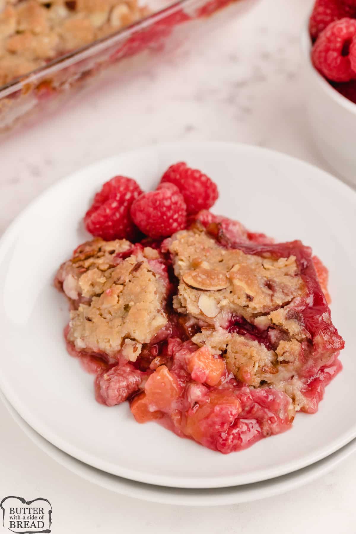 Raspberry Peach Crumble made with fresh peaches and raspberries covered with a sweet, crunchy almond topping. Delicious peach dessert that only takes a few minutes to prepare! 