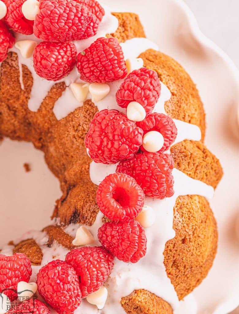 white bundt cake topped with raspberries