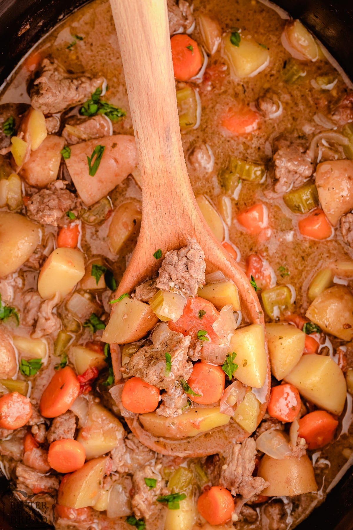 wooden spoon dishing up beef stew