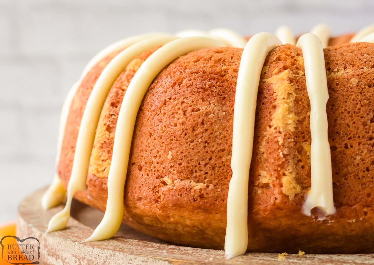 orange bundt cake with thick lines of cream cheese frosting
