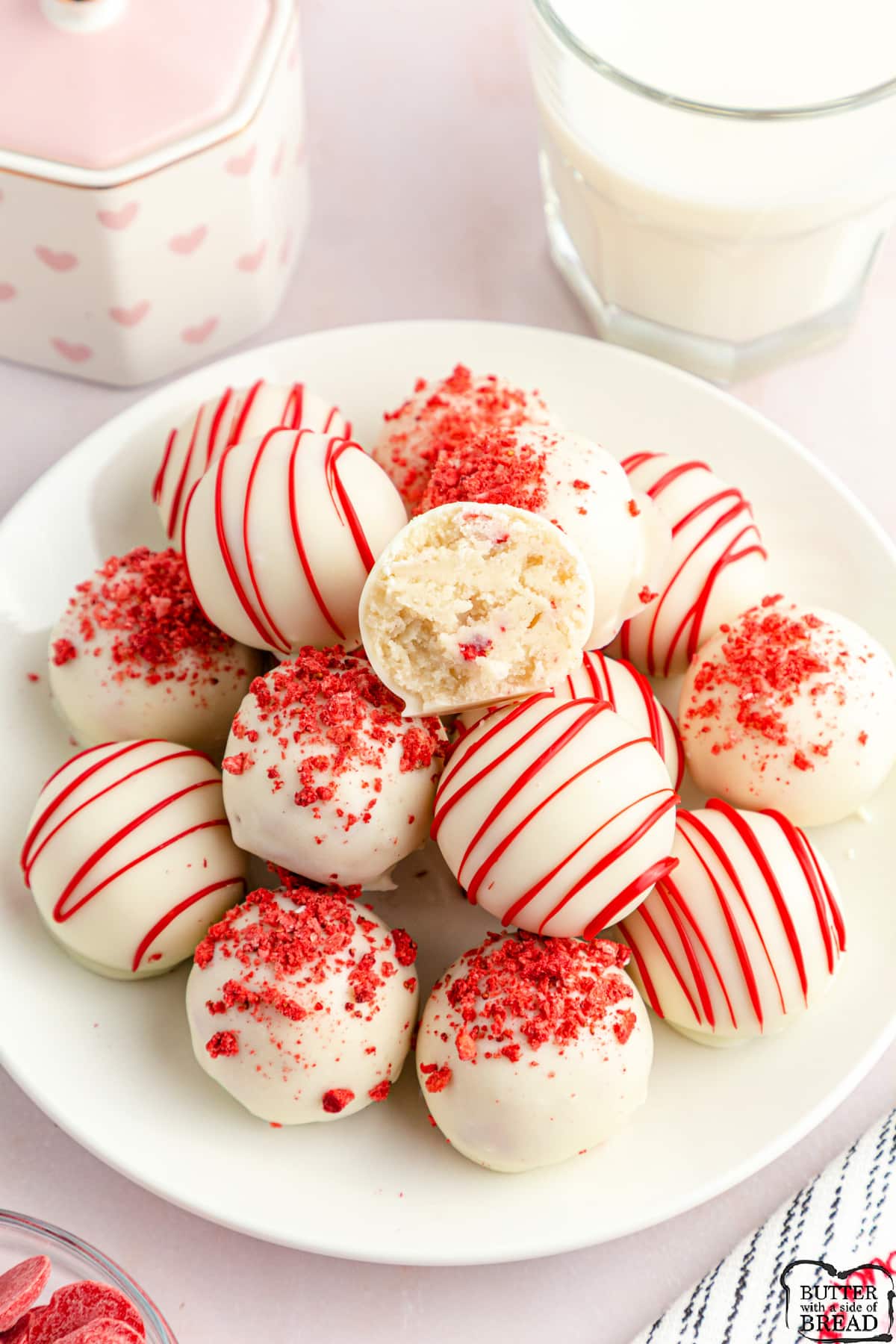 Strawberry Cake Mix Cake Balls made with a vanilla cake mix, cream cheese and freeze dried strawberries. Dip the cake balls in melted chocolate and add some sprinkles. Simple no bake dessert that is perfect for parties and holidays!