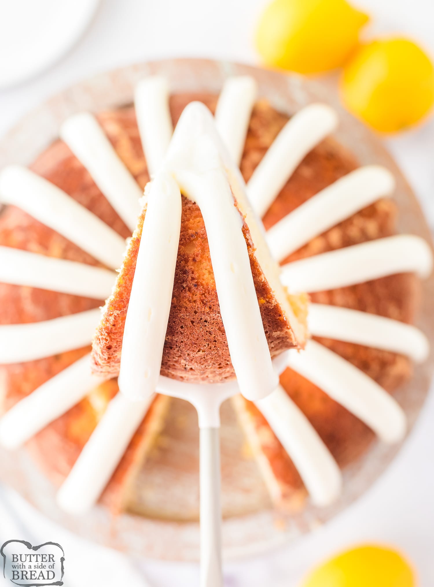 slice of lemonade bundt cake with pined lines of frosting