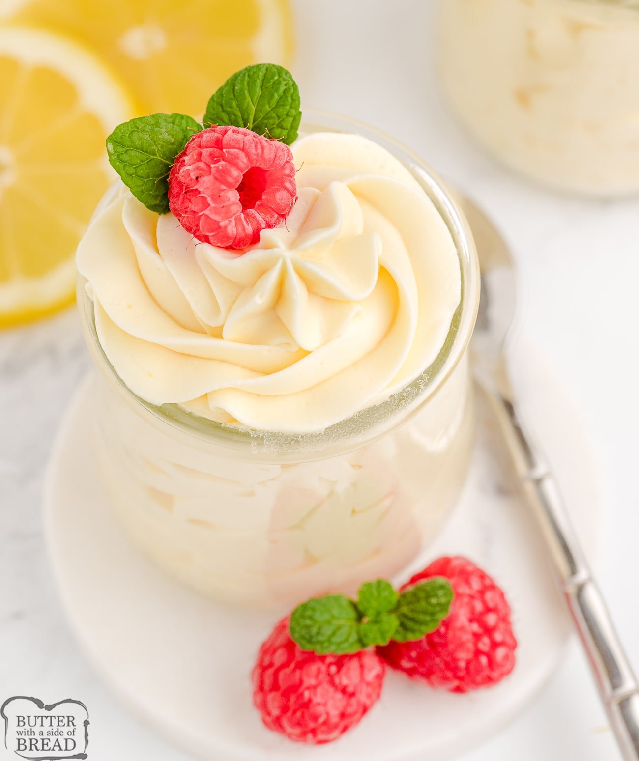 lemon mousse in a parfait glass with raspberries