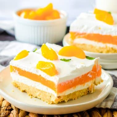 orange lush dessert with layers of jello and cream