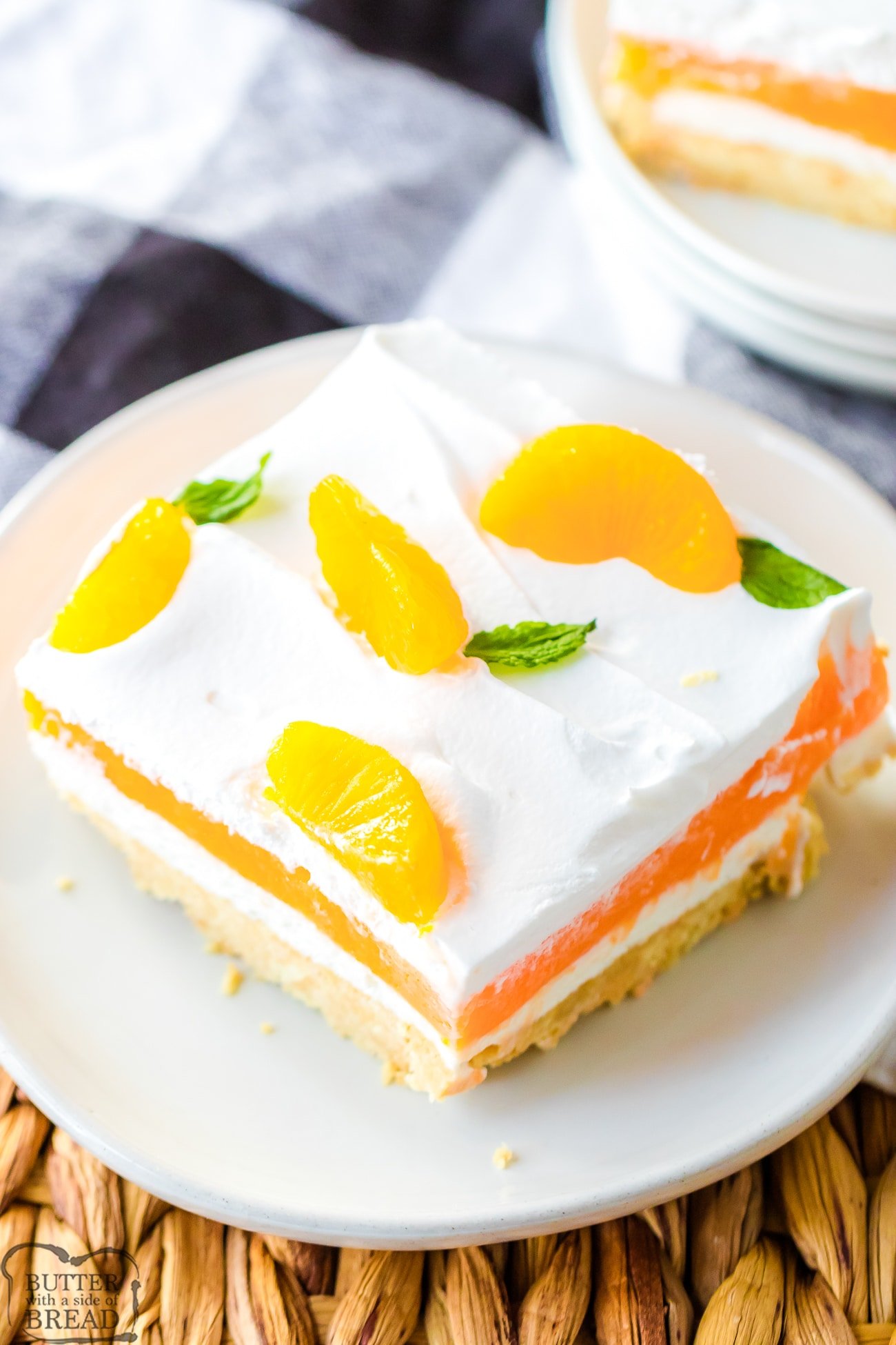 layered orange lush dessert with oranges and cream on top