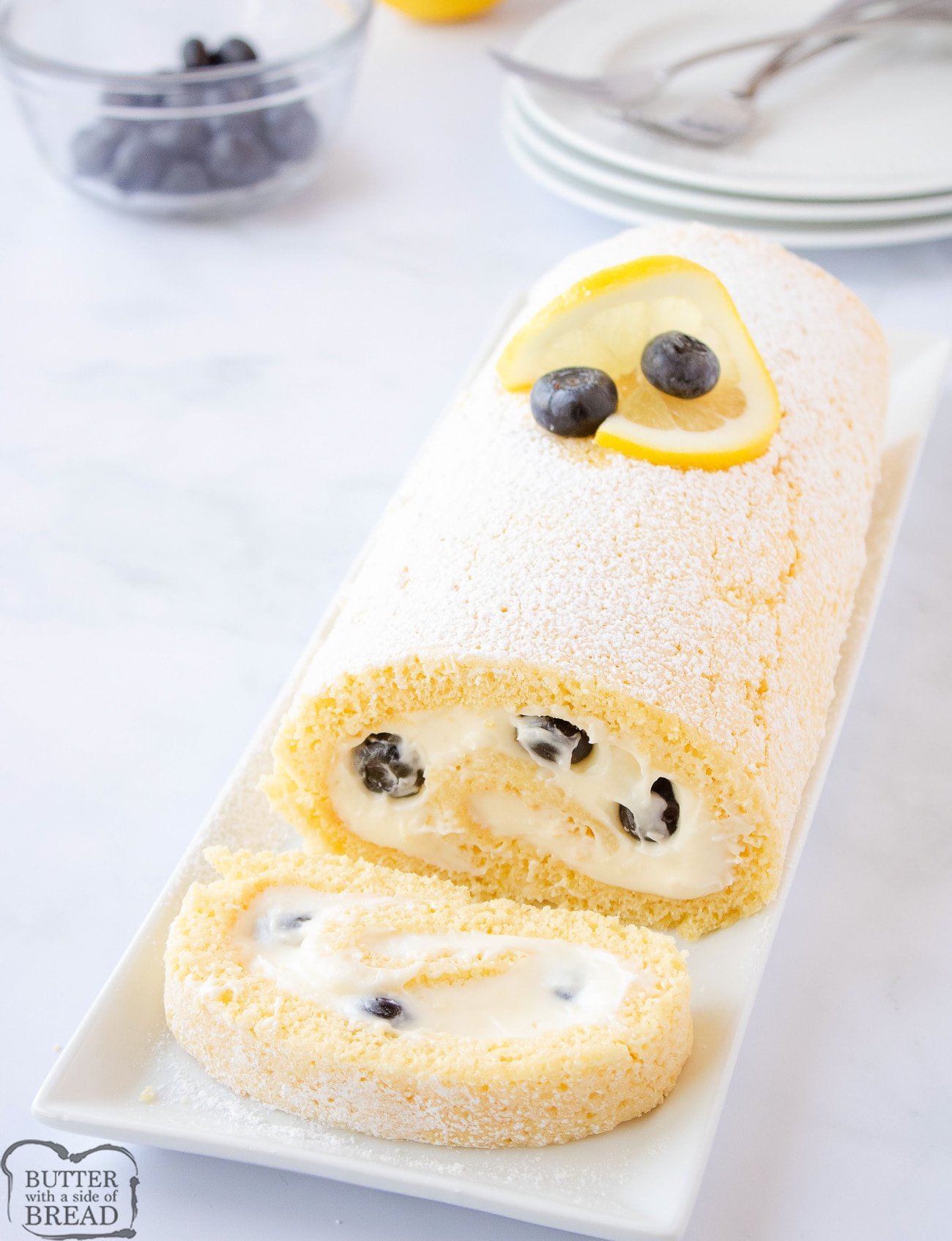 blueberry lemon cake roll with a slice cut off the end