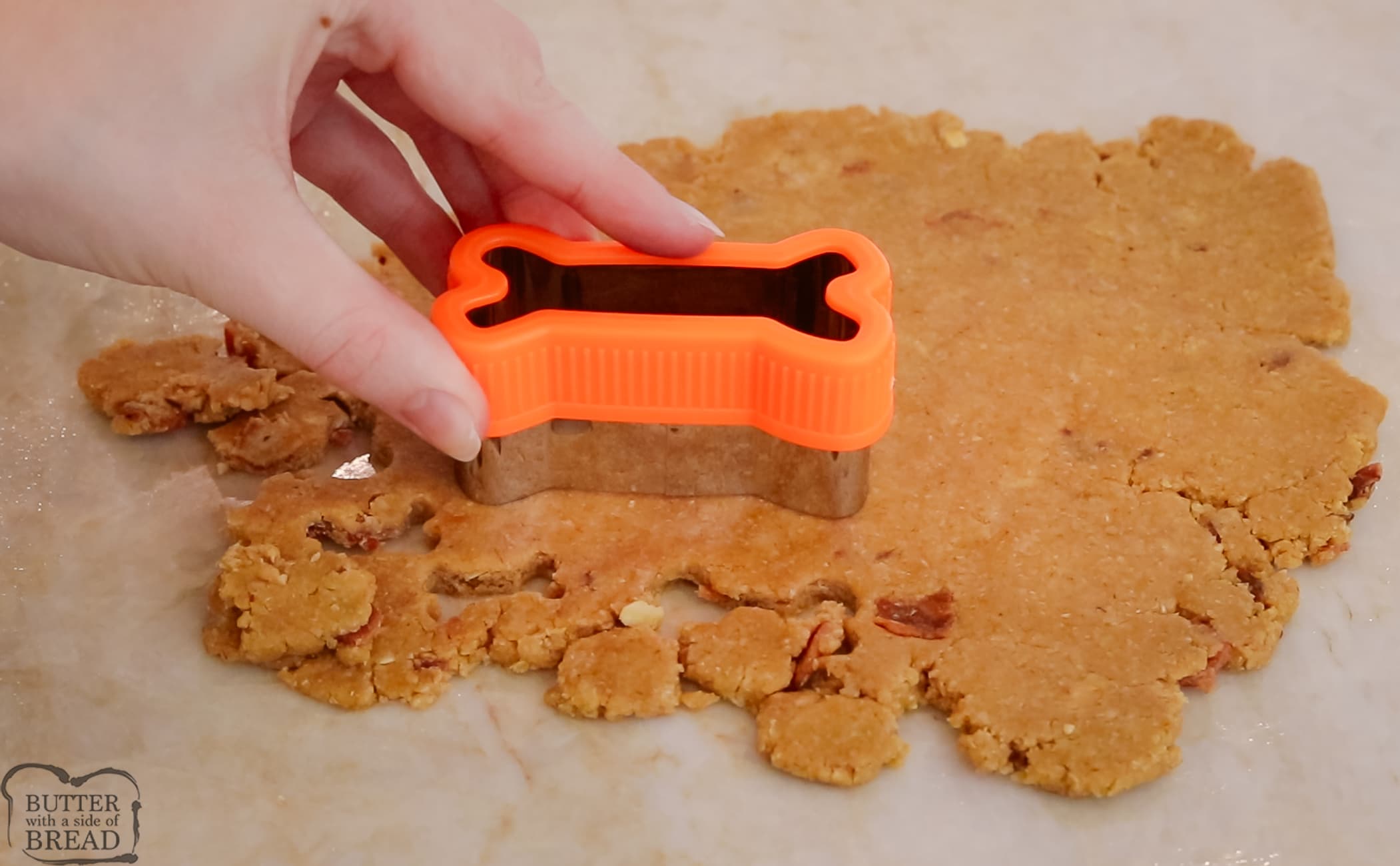 using a bone shaped cookie cutter to make homemade dog treats