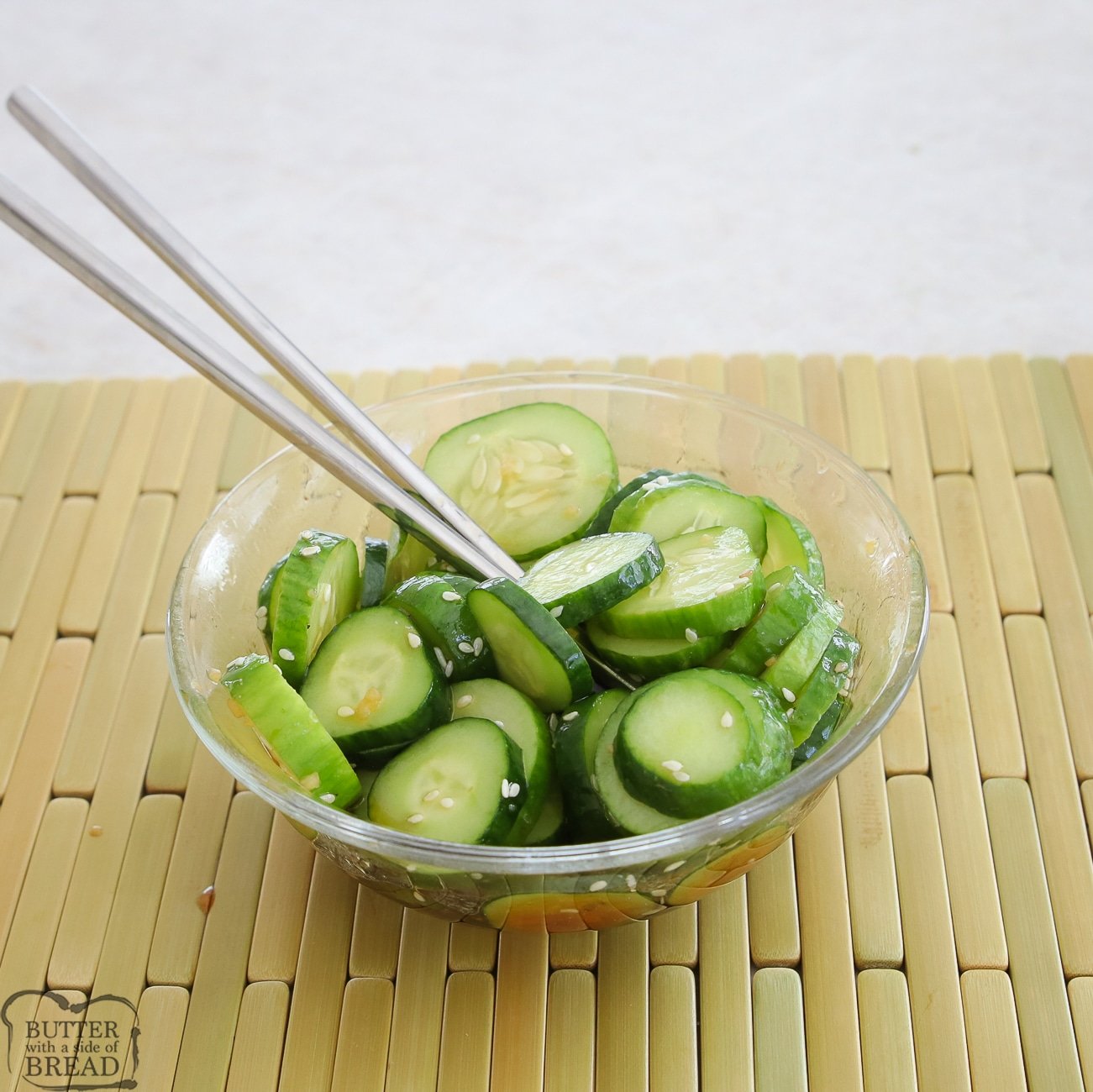 simple cucumber salad in a glass bowl with chopsticks