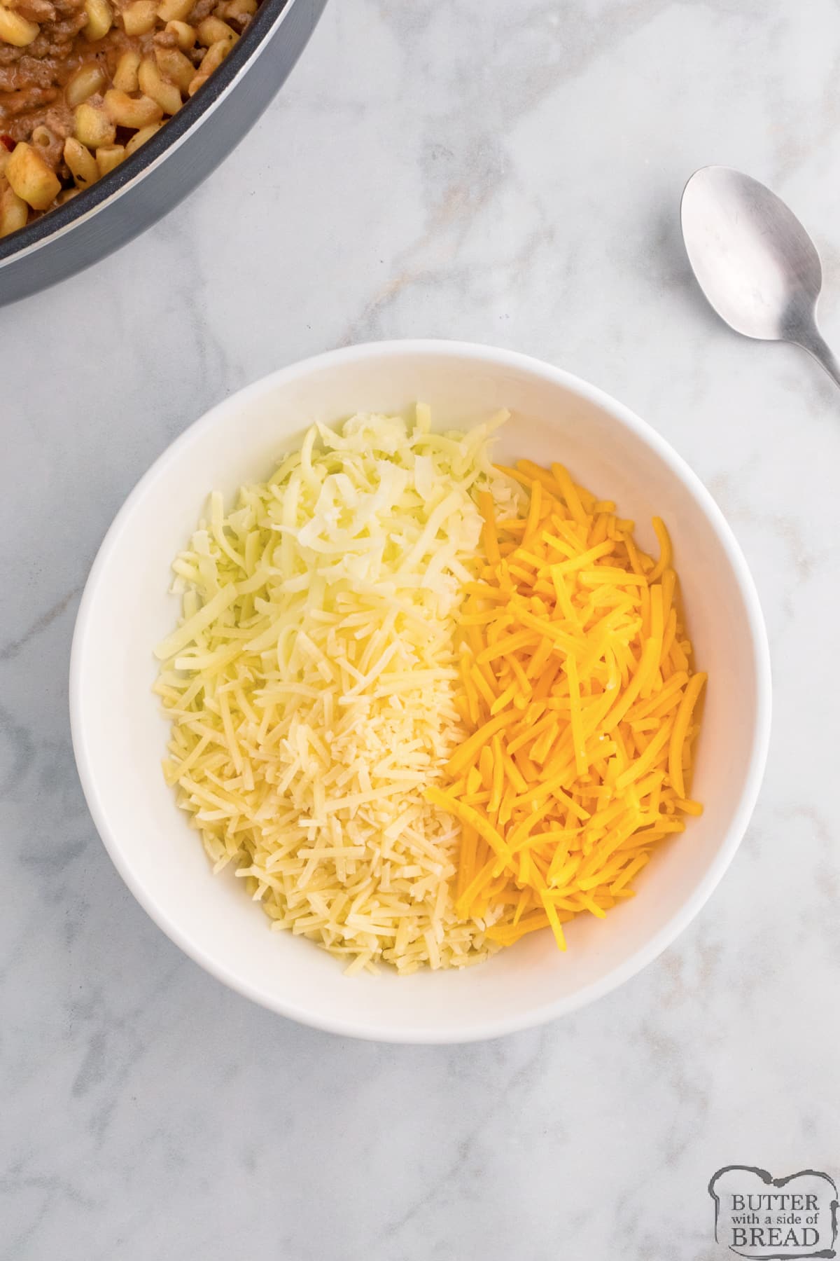 Combining three types of cheese in a bowl.