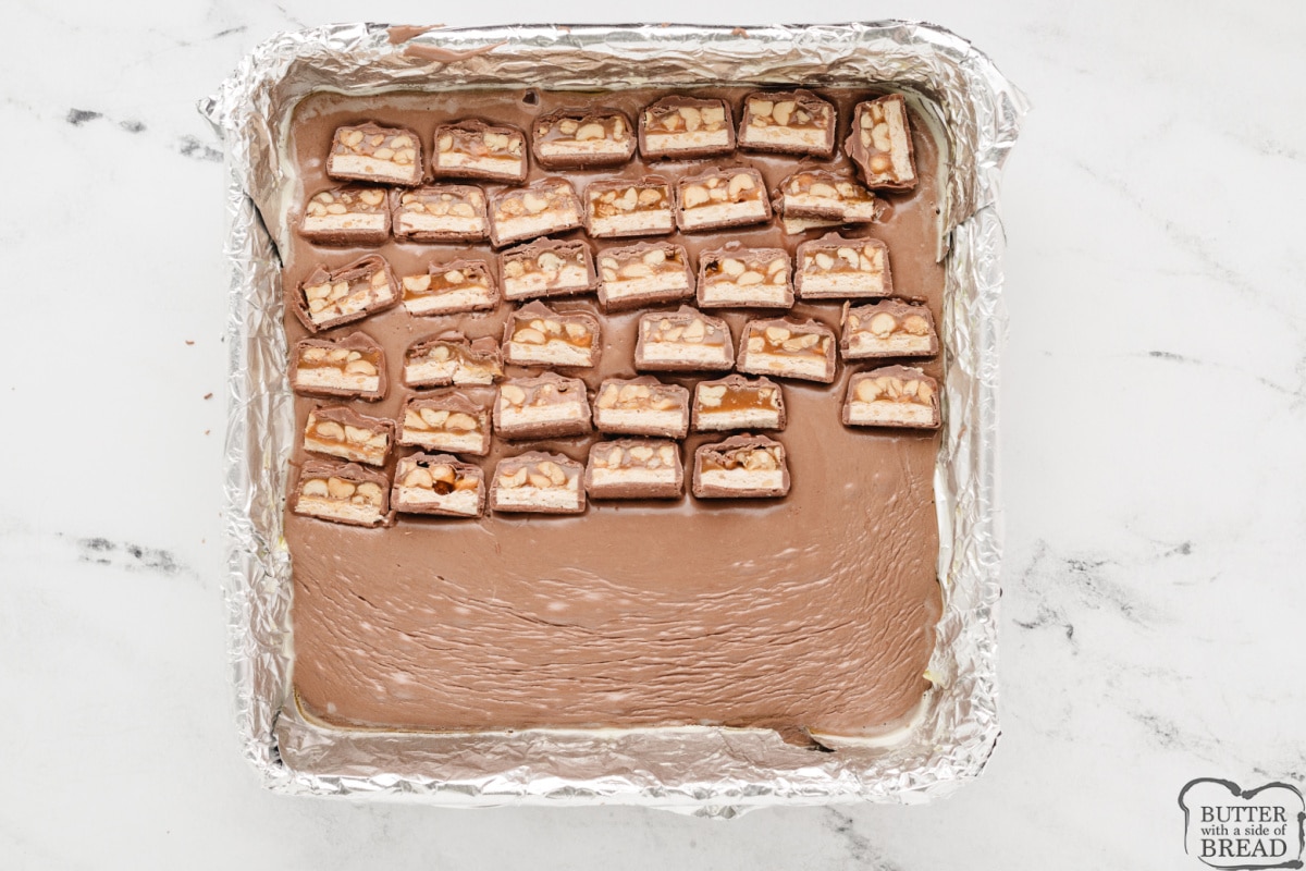 Layering sliced Snickers bars in the middle of the fudge. 