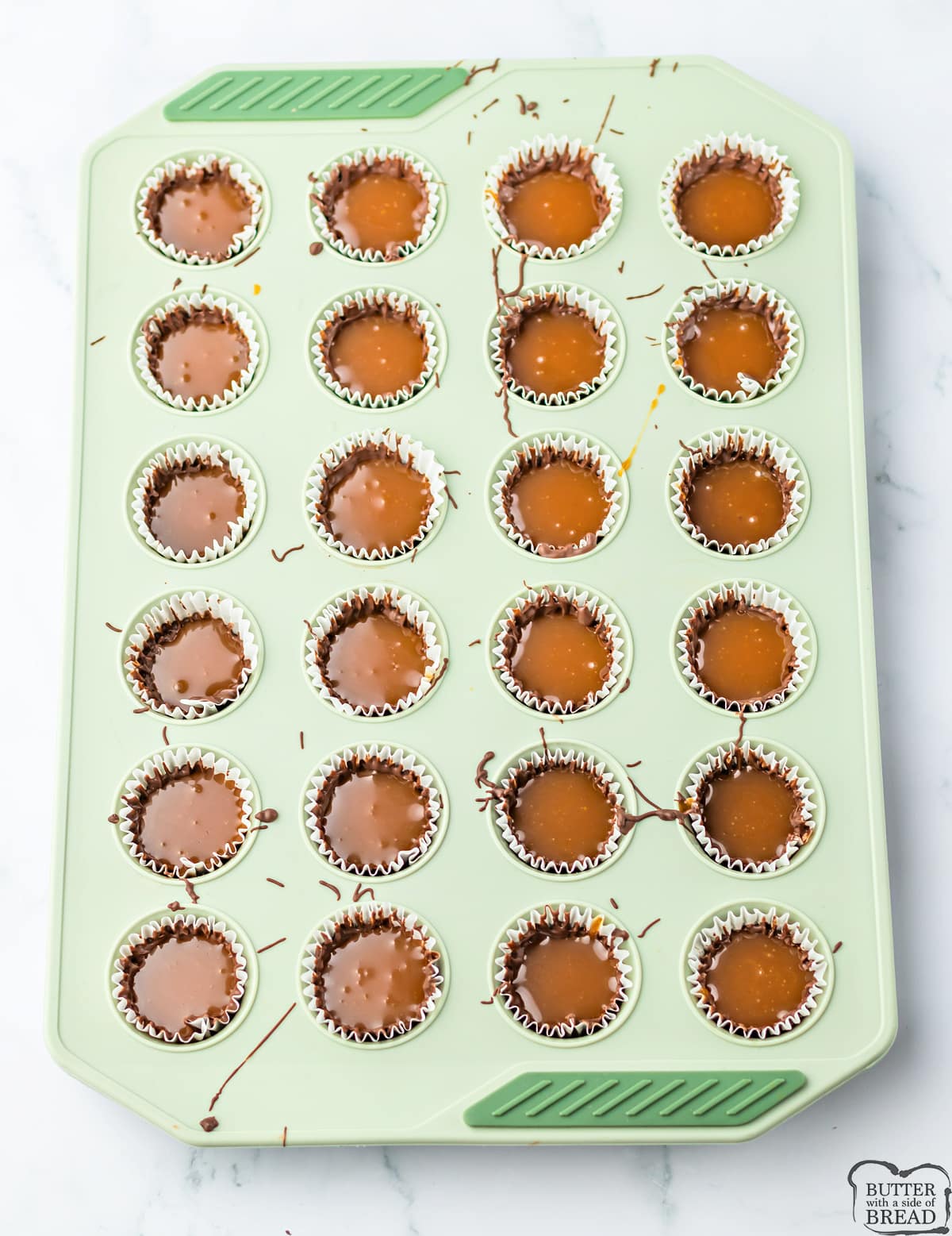 Adding caramel filling to chocolate cups.
