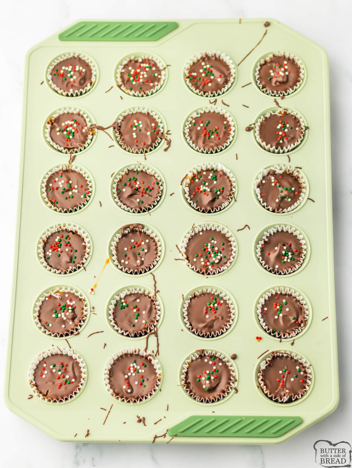 Adding chocolate and sprinkles to chocolate caramel cups.