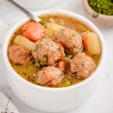 meatball stew in a white bowl with a spoon