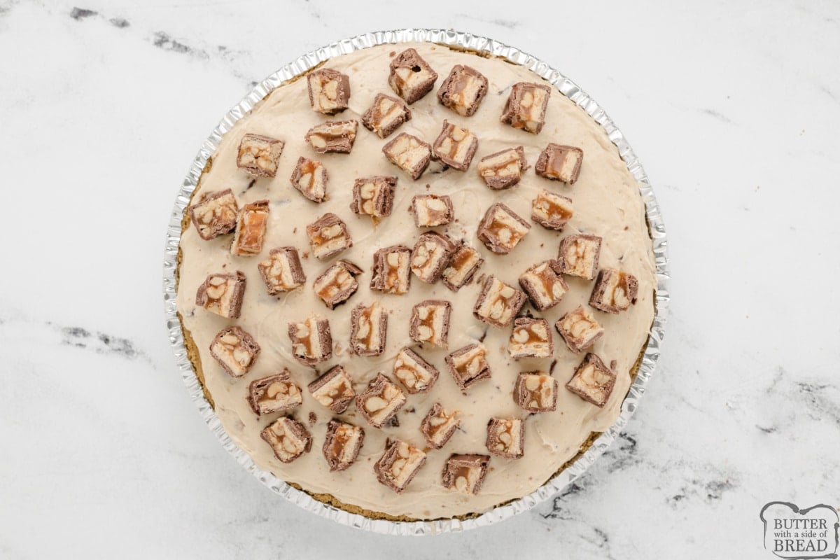 Assembling No Bake Snickers Pie. 