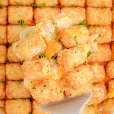 scooping out tater tot casserole