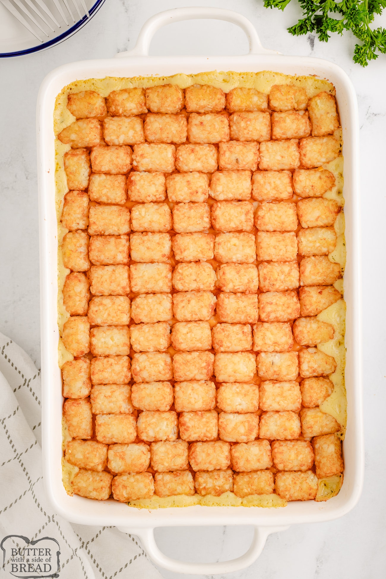 chicken tater tot casserole baked in a white dish