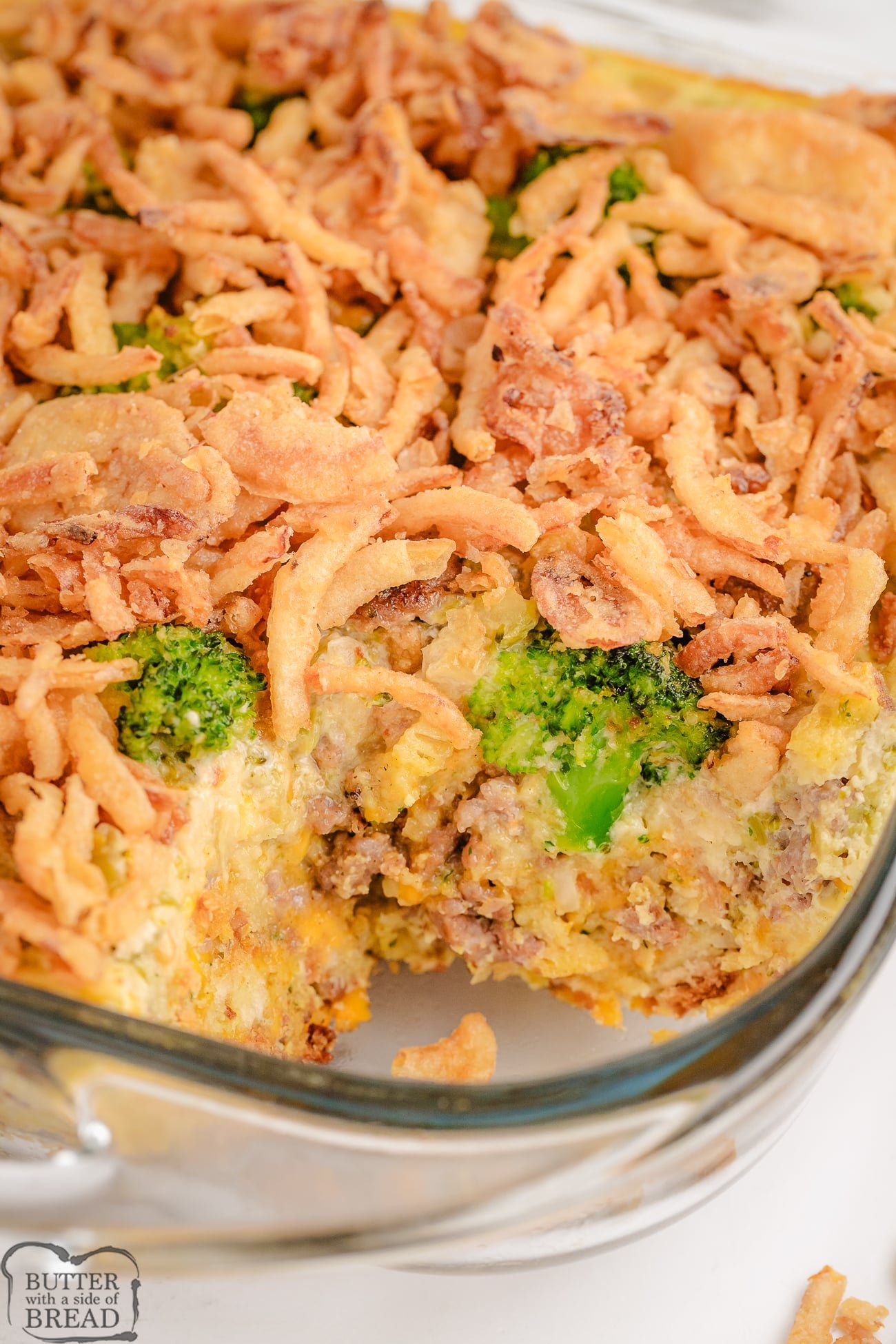 sausage broccoli casserole in a baking dish with a scoop taken out
