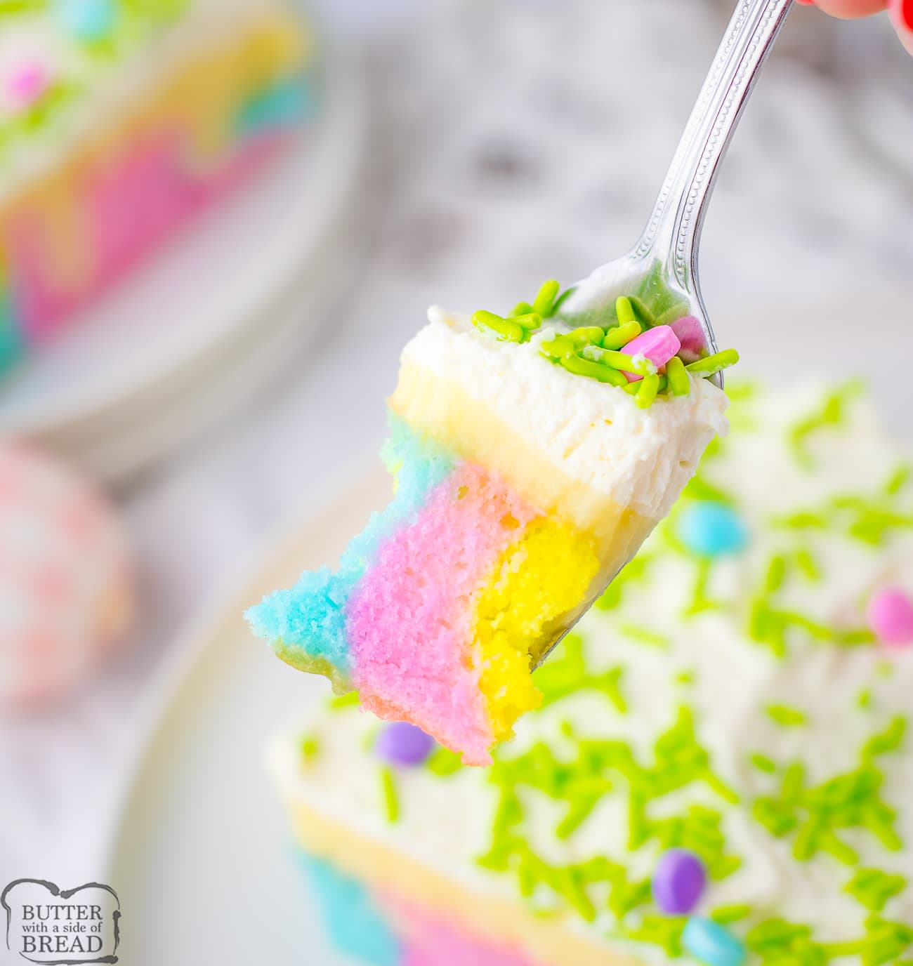 bite of multi colored poke cake for Easter