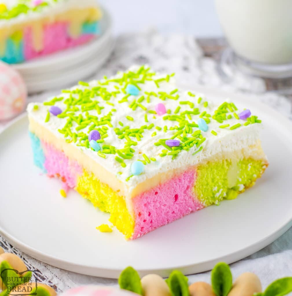 colorful poke cake with whipped cream and sprinkles