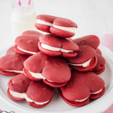 heart shaped red velvet whoopie pies piled on a white plate