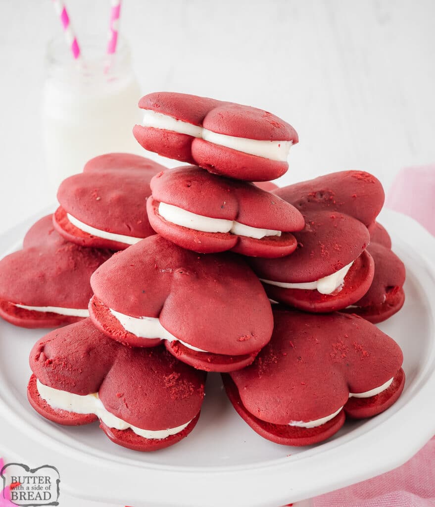 heart shaped red velvet whoopie pies piled on a white plate