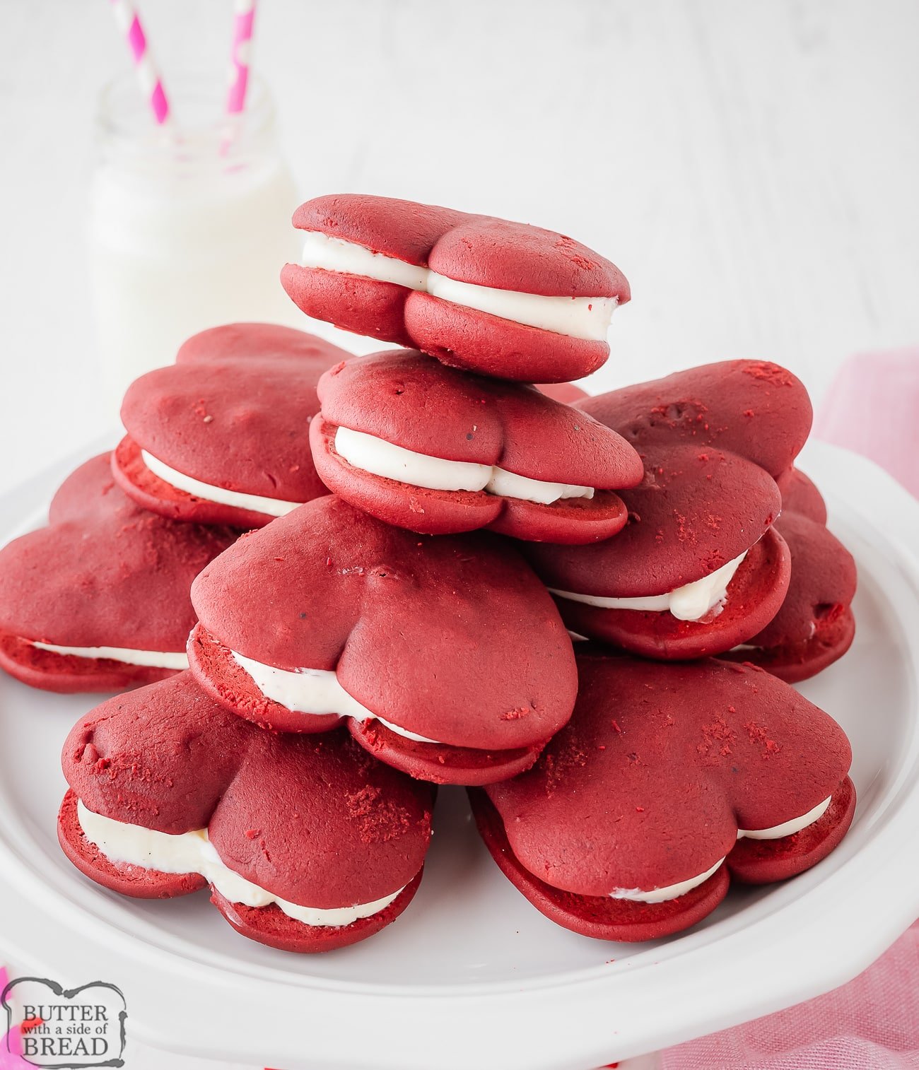 heart shaped red velvet whoopie pies piled on a white plate