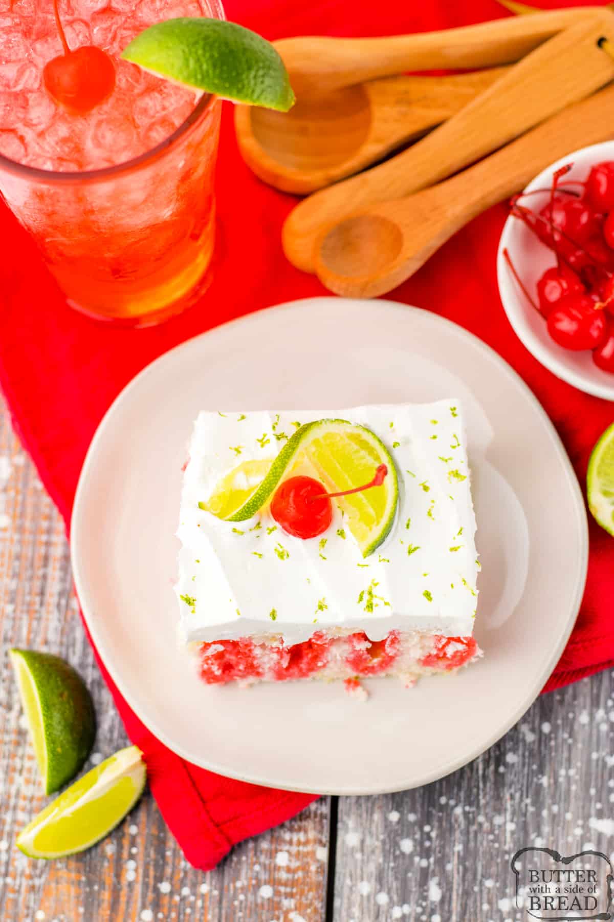 Slice of poke cake with lime and cherry. 