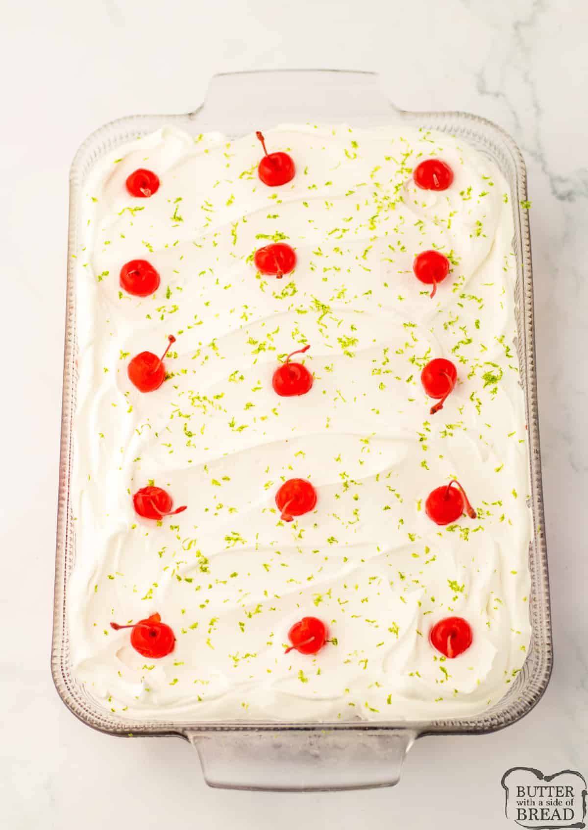 Frost cake with Cool Whip and top with lime zest and maraschino cherries. 