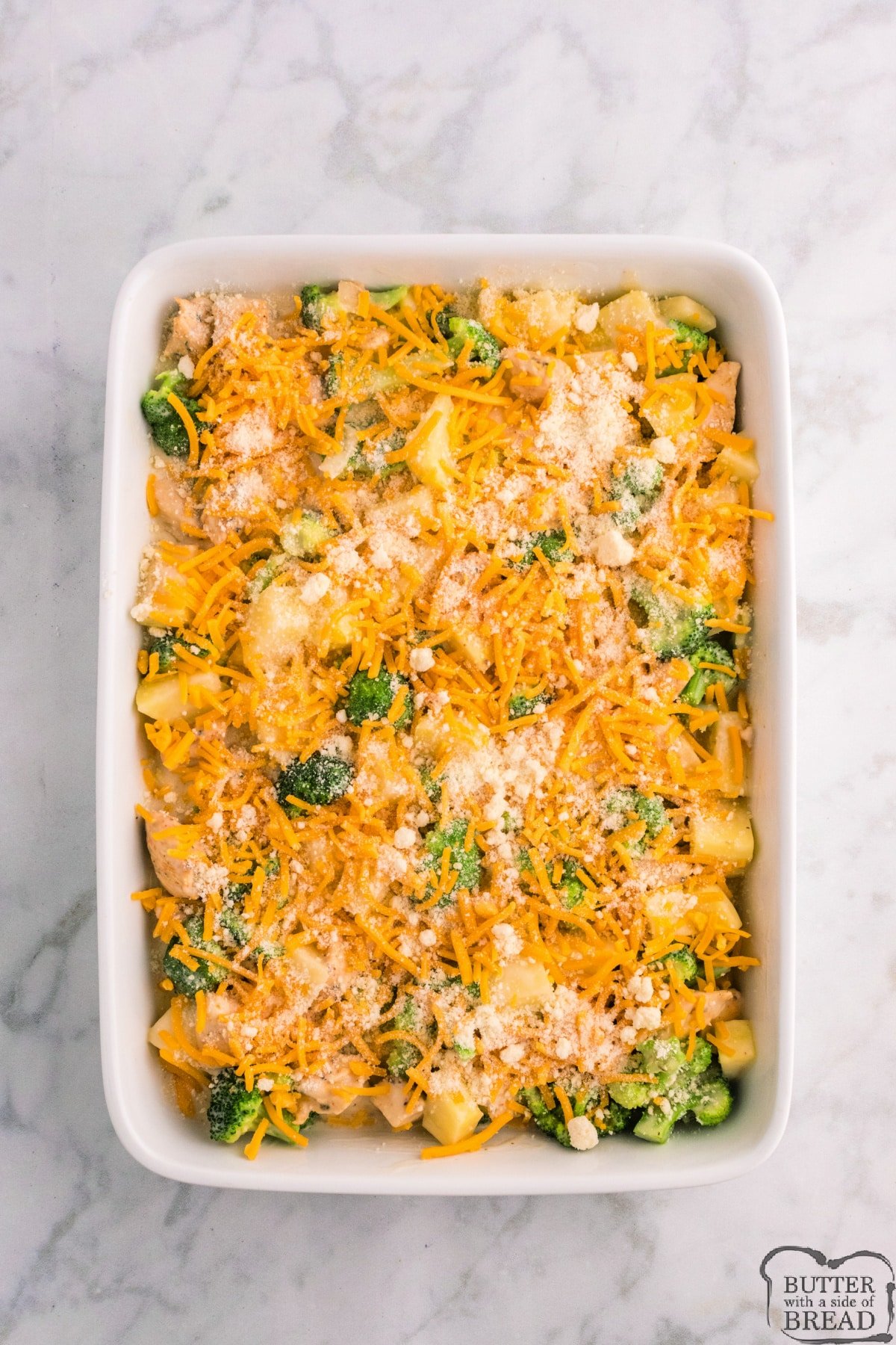 Assembling the chicken broccoli potato casserole with cheese on top. 
