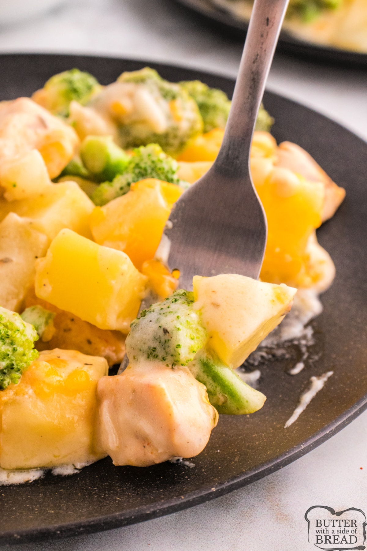 Bite of casserole with broccoli, potatoes, and chicken. 