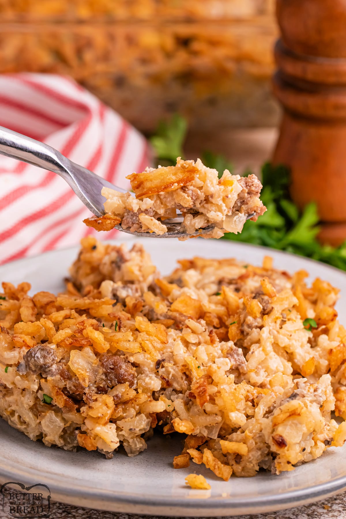 Scoop of casserole made with ground beef, rice, and french fried onions. 