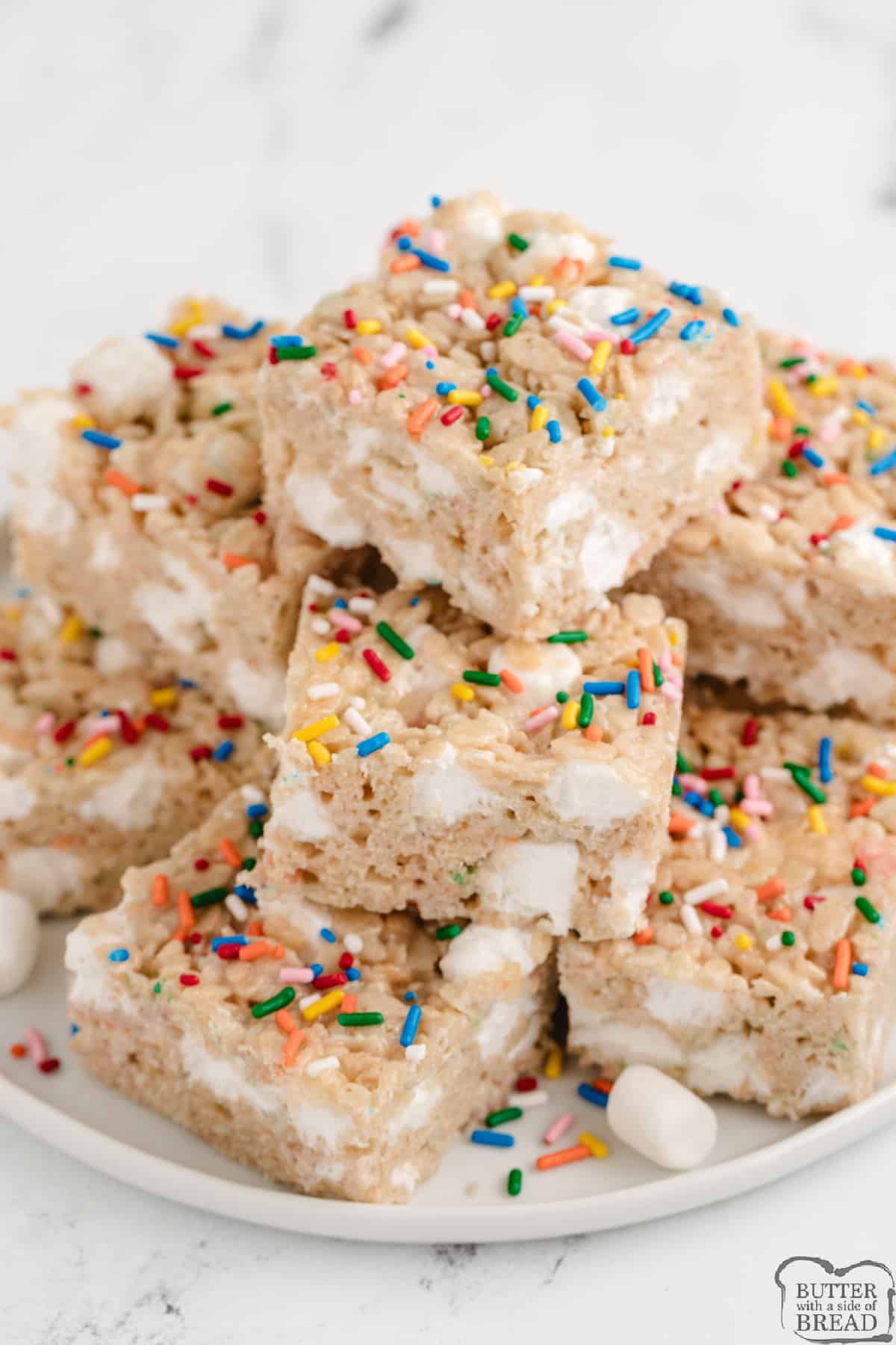 Plate of rice krispie treats with sprinkles and funfetti cake mix. 