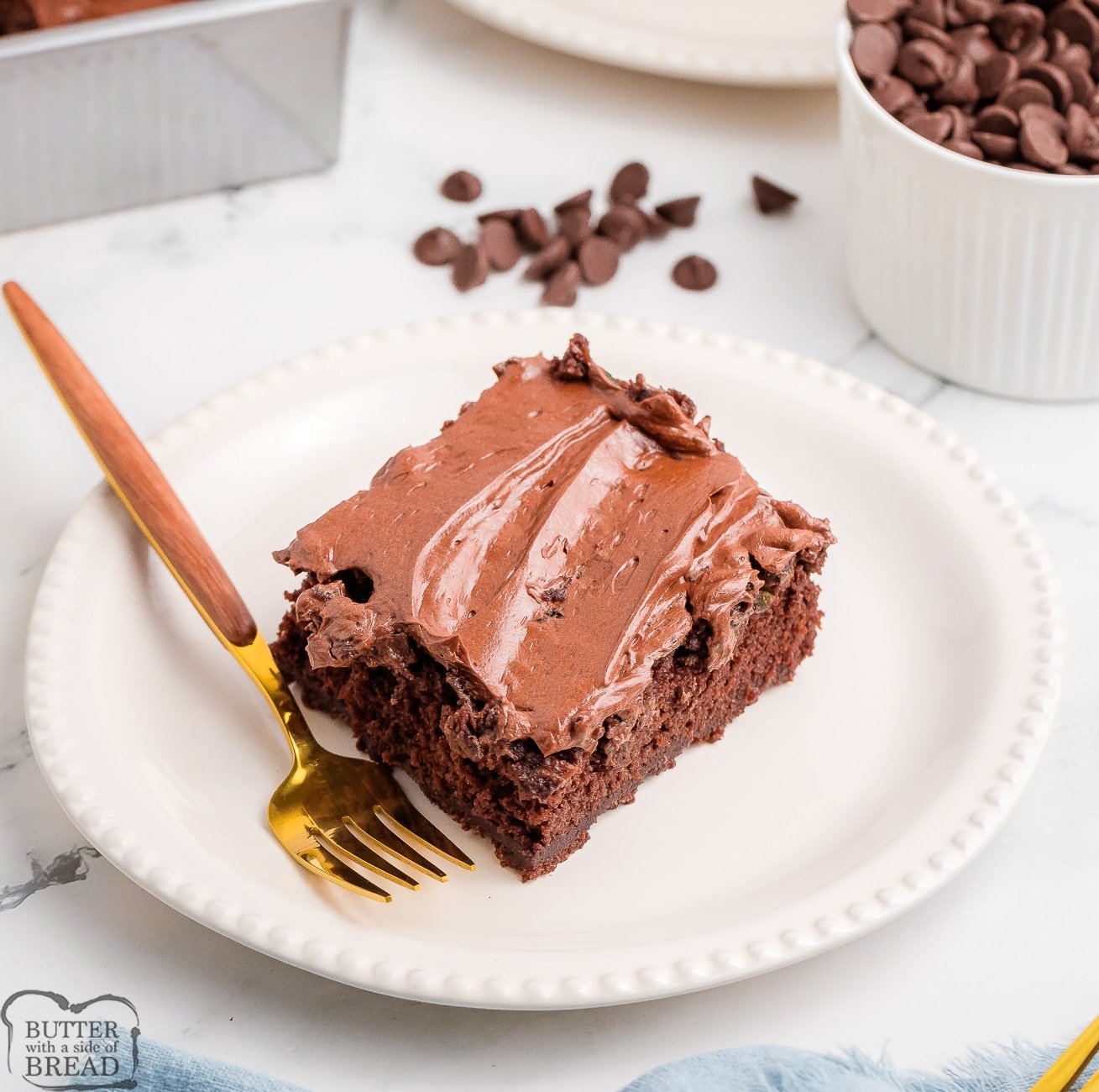 slice of chocolate zucchini cake topped with whipped chocolate ganache