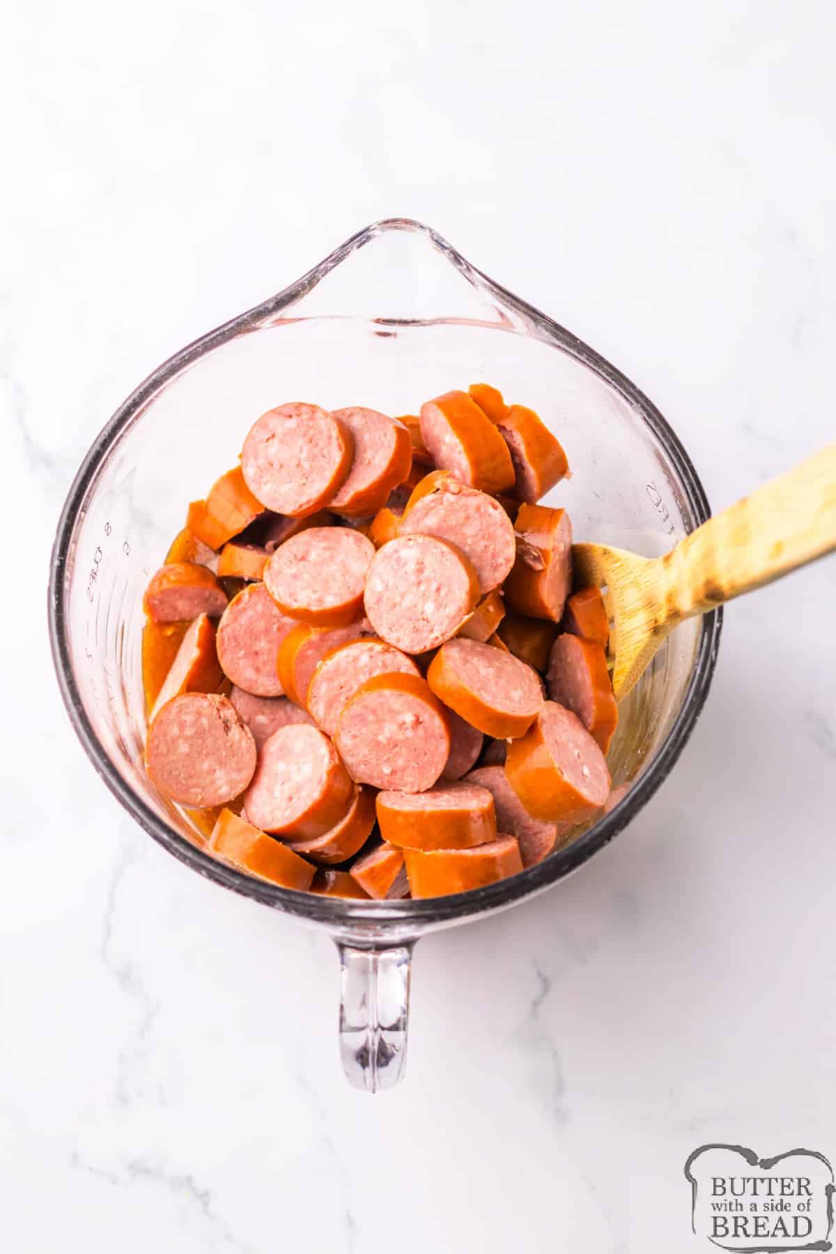 Mixing sliced sausage in the glaze. 