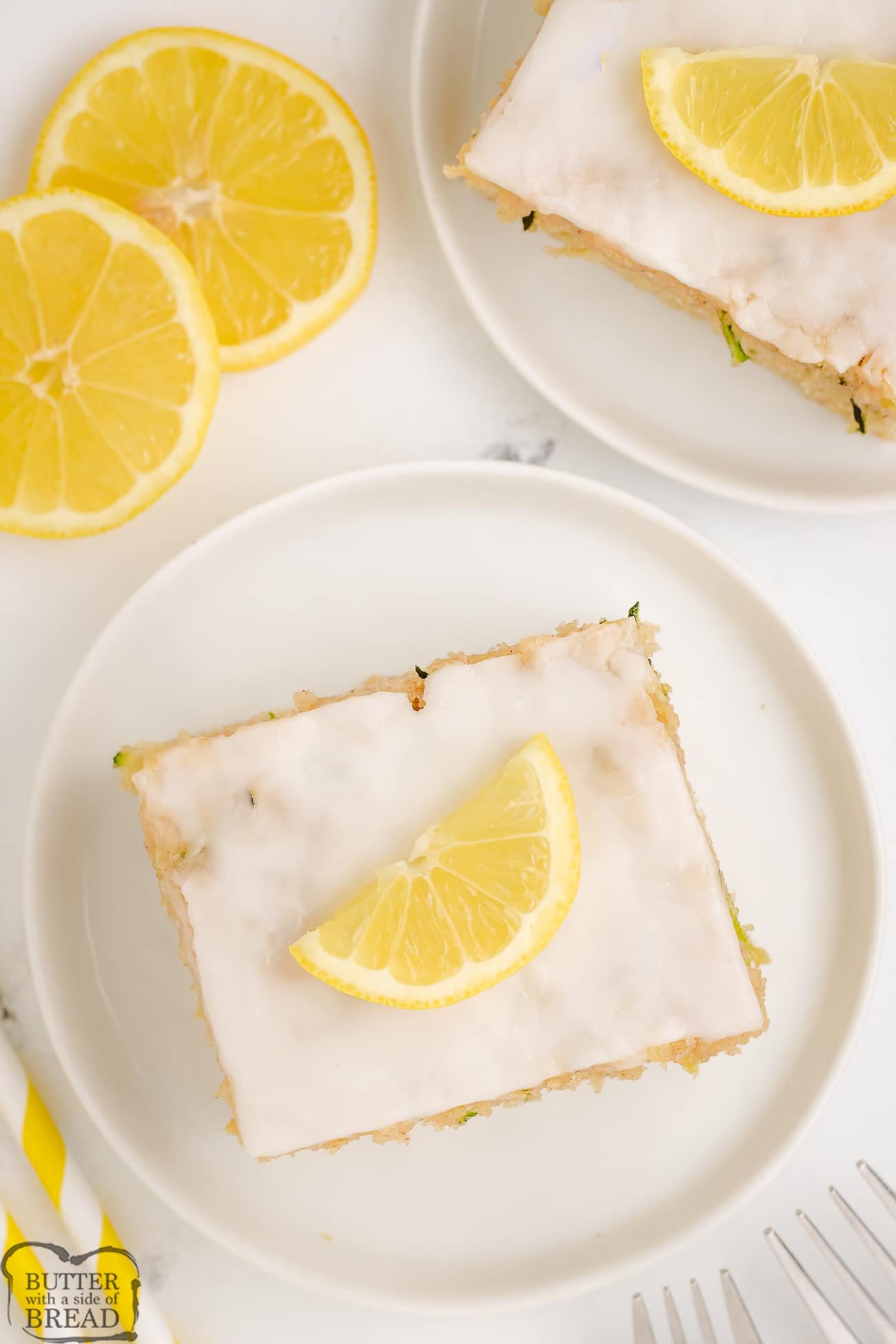 lemon zucchini cake topped with a lemon glaze and slice of fresh lemon