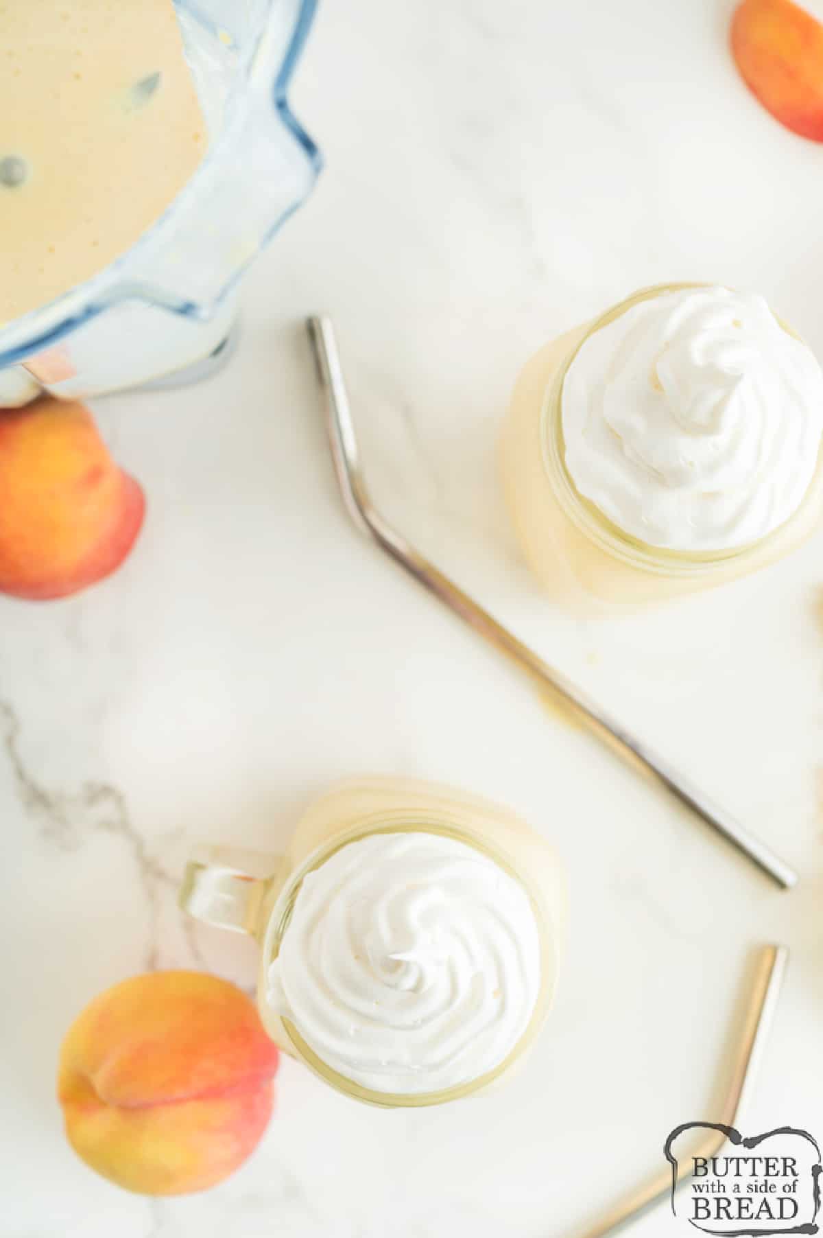 Peach milkshakes with whipped cream on top.