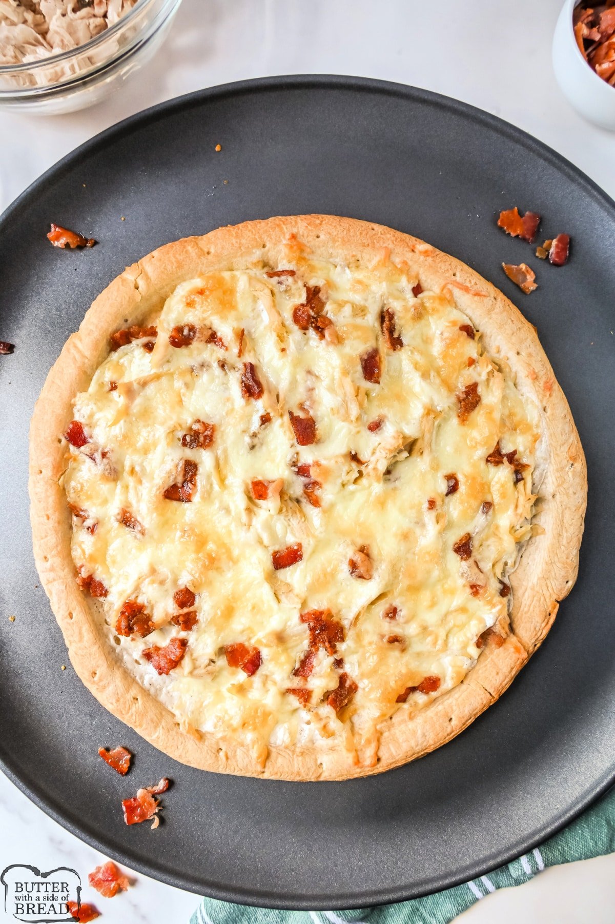 Baked pizza with chicken, bacon, and ranch dressing.